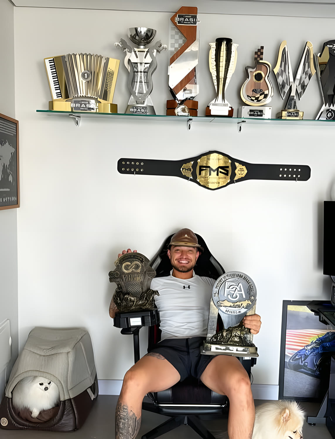 MC Gui na sala de troféus, com o cinturão do Fight Music Show na parede